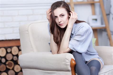 Een Aantrekkelijk Flirty Jong Brunette Zit Als Grote Zachte Voorzitter Stock Foto Image Of