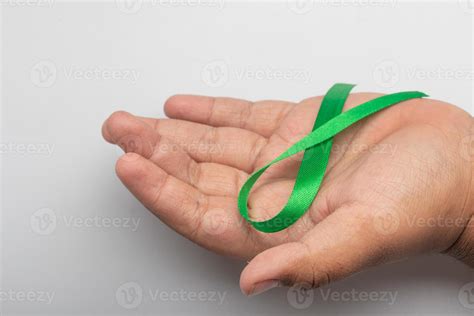 cinta verde en la mano concepto de tratamiento para el cáncer de ovario