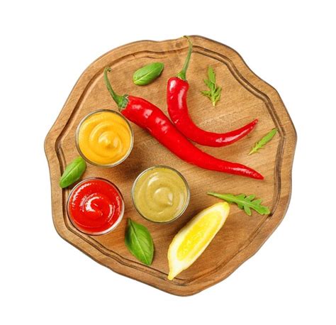 Placa de madera con diferentes salsas de chile y rodaja de limón sobre