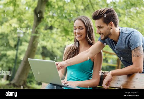 Los adolescentes que estudian en el parque una chica está sentado en