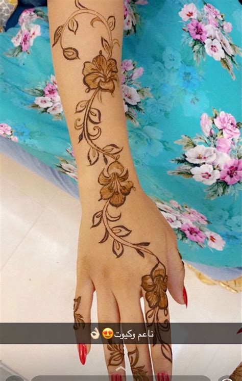 A Woman S Hand With Henna Tattoos On It And Flowers Painted On The Arm