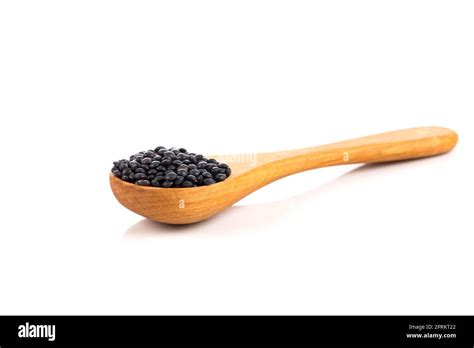 Black Organic Lentils In Wooden Spoon Isolated On White Background