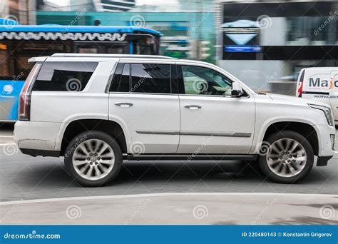 Side View Of Cadillac Escalade Suv In Motion White Big 4x4 Car Moving On The Street Editorial