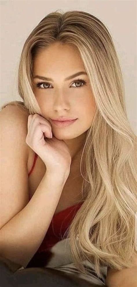 A Beautiful Blonde Woman Laying On Top Of A Bed