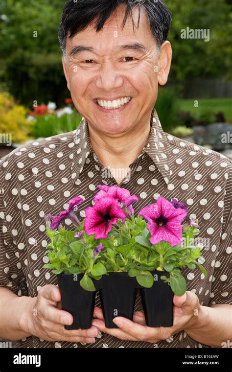 Senior Asian Man Holding Potted Plants Stock Photo Alamy