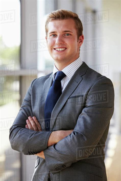 Portrait of a young smiling professional man, arms crossed - Stock Photo - Dissolve