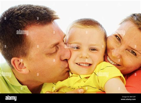 Portrait Of Happy Kid Being Kissed By His Parents Stock Photo Alamy