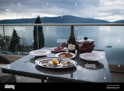 Table with local food and wine on home balcony. Focus on bottle ...