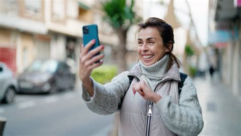 Middle Age Hispanic Woman Smiling Confident Making Selfie By The