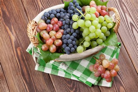 Racimo De Uvas Rojas Moradas Y Blancas En Cesta Foto Premium