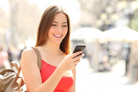 Woman Using A Smart Phone In The Street In Summer Stock Photo