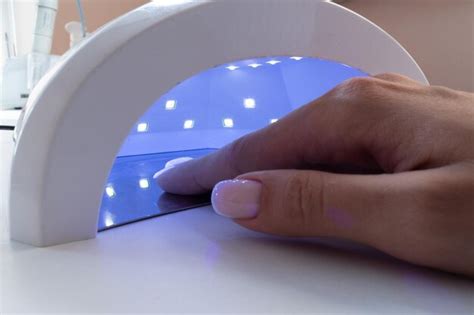 Premium Photo Female Hand Inside Drying Uv Light Machine In Nail Salon