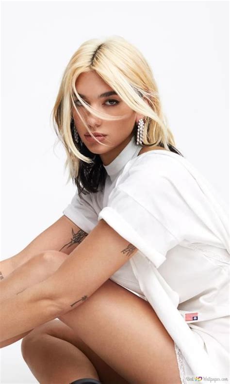 Dua Lipa With Blonde Hair In A White Outfit And Black Shoes White Background 4K Wallpaper