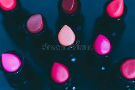 Group Of Red Pink And Nude Lipsticks With Different Colors And Textures On Dark Table Stock
