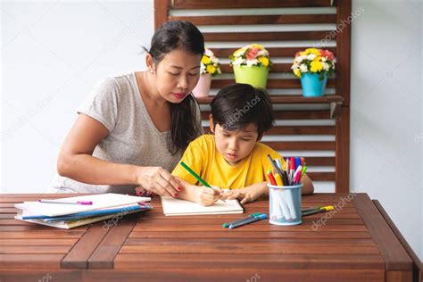 La tarea de los niños Joven chico de raza mixta haciendo la tarea en