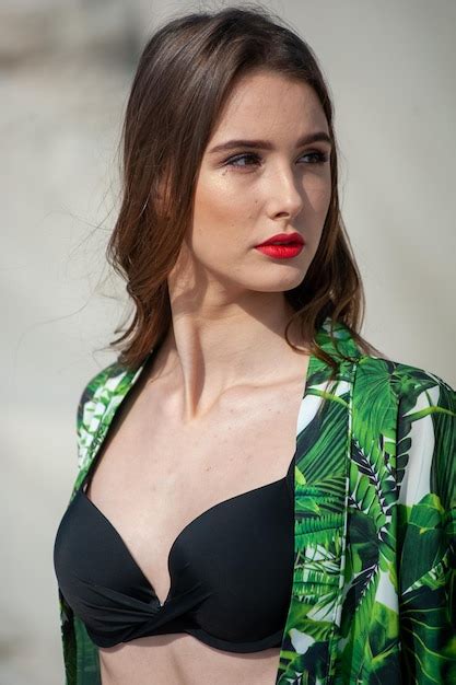 Una Modelo Lleva Un Top De Bikini Verde Con Un Top De Bikini Negro Y Un Estampado De Hojas De