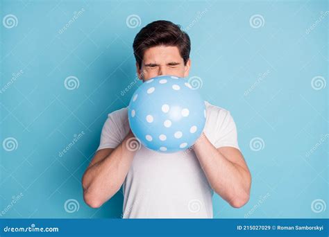 Photo Of Optimistic Man Blow Balloon Closed Eyes Wear White T Shirt