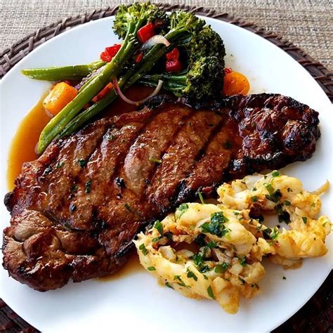 A White Plate Topped With Meat And Veggies On Top Of A Woven Place Mat