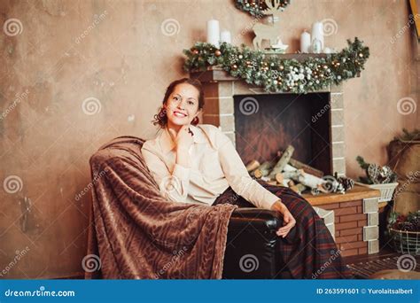 Young Woman Sitting By The Fireplace In A Cozy Living Room Stock Image