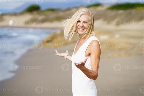 Happy Mature Woman Walking On The Beach Spending Her Leisure Time