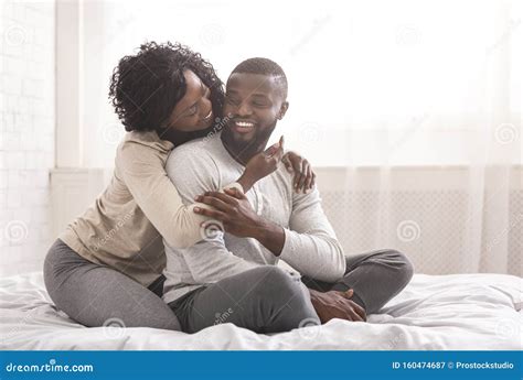 Romantic Millennial Couple Cuddling While Sitting In Bed In Morning