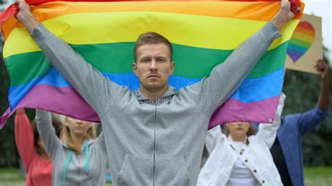 Handsome Man With Rainbow Flag Amid Protesters For Gay Rights Lgbt Pride Event Stock Photo