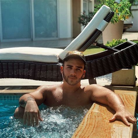 A Man Is Sitting In The Pool With His Arms Out