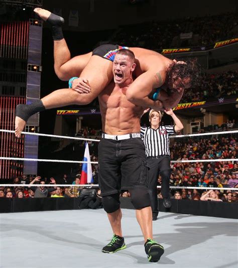 A Man Is Doing A Handstand In The Middle Of A Wrestling Ring