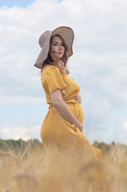 Uma Jovem E Linda Mulher Gr Vida Um Vestido E Chap U Amarelo