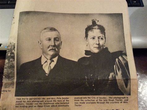 an old photo of two people sitting next to each other on top of a table