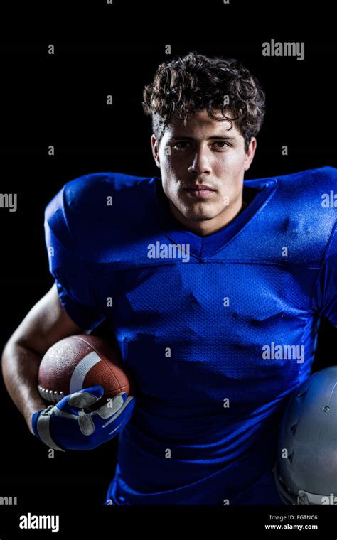 Portrait Of Serious American Football Player Holding Ball And Helmet