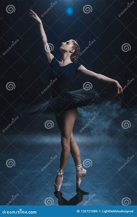 Attractive Elegant Ballerina Dancing In Pointe Shoes And Black Tutu In