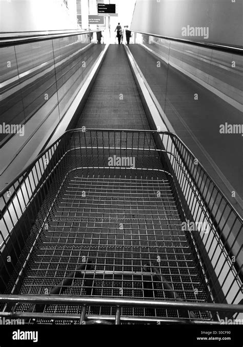 Einkaufswagen auf einer Rolltreppe in schwarz weiß Stockfotografie