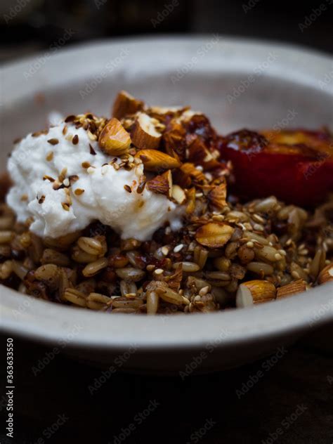 Wholefoods healthy grains, nuts and seeds granola breakfast in rustic natural light setting and ...