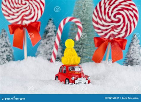 Red Santa Car With In Yellow Winter Cap And Christmas Tree Forest With