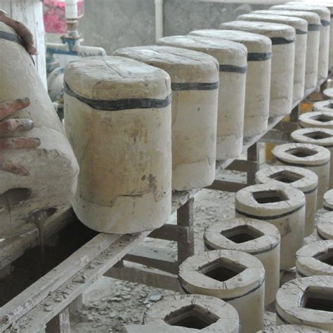 Several Cement Cylinders Are Lined Up In A Factory