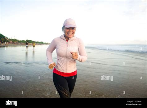 Fit And Attractive Mature Woman With Grey Hair Doing Beach Workout On Her S Running On The