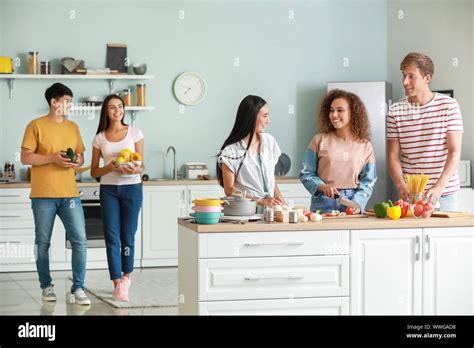 Happy Friends Cooking Together In Kitchen Stock Photo Alamy