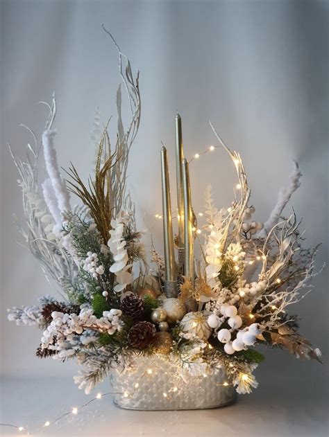 A White Vase Filled With Lots Of Different Types Of Flowers And Candles