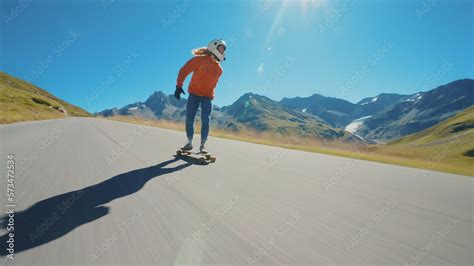 Cinematic downhill longboard session. Young woman skateboarding and ...