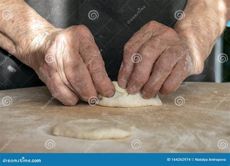 The Old Woman`s Overworked Hands Are Making Pies Out Of Dough Stock