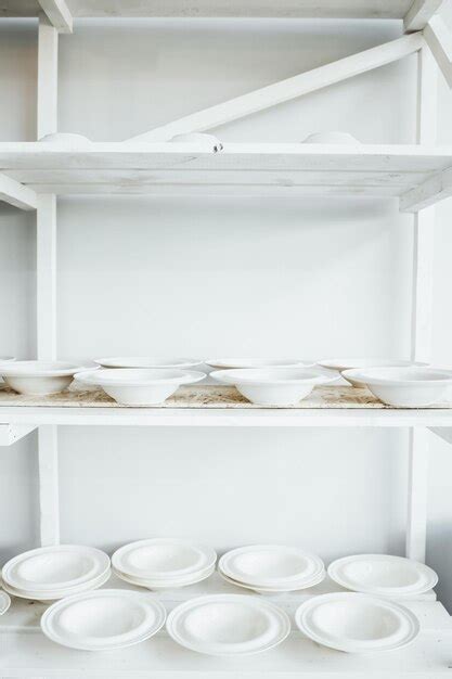 Premium Photo White Plates On The Shelving In A Pottery Workshop