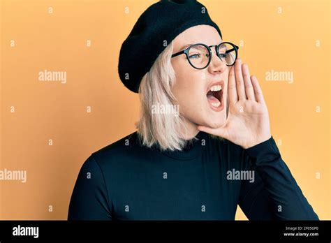 Jeune fille blonde portant le regard français avec le cri de béret et criant fort à côté avec la