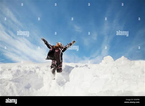 Caucasian Girl Jumping On Snowy Hillside Stock Photo Alamy