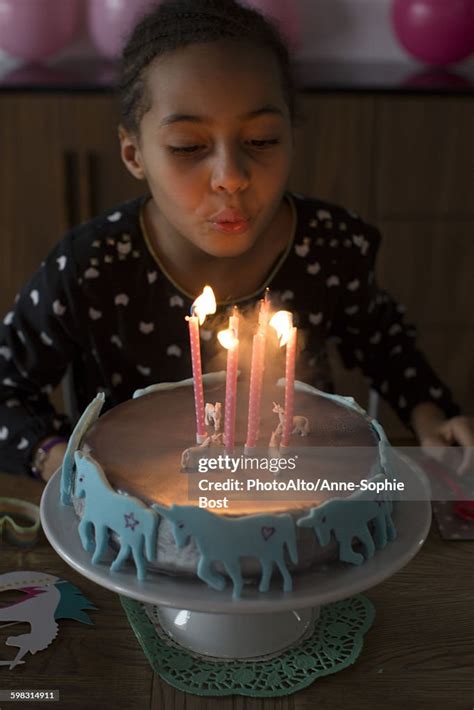 Girl Blowing Out Candles On Birthday Cake Photo Getty Images