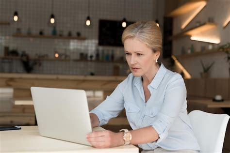 Premium Photo Serious Mature Businesswoman Using Laptop In Cafe