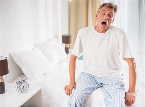 Premium Photo Senior Man Is Sitting In Bed And Yawning