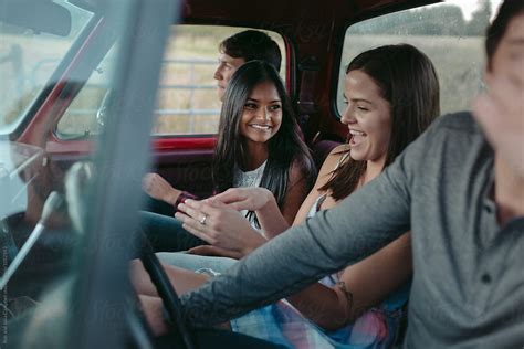 Young Friends Enjoying Summer Road Trip Together In Old Truck By