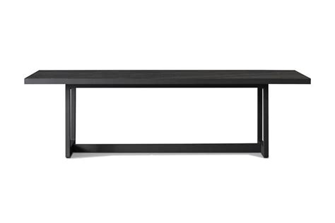 a black table sitting on top of a white floor next to a wooden frame ...