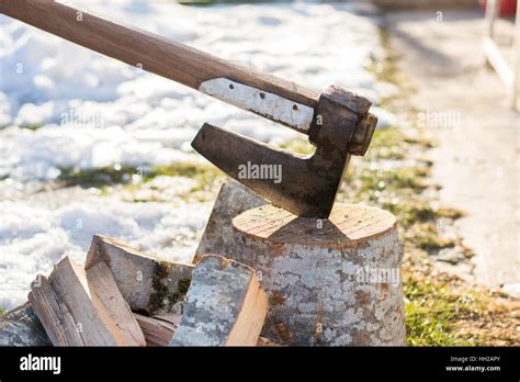 Axe stabbed in the firewood in the front yard Stock Photo - Alamy